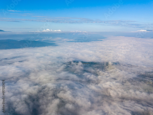 High flight above the clouds in the mountains. Aerial drone view.