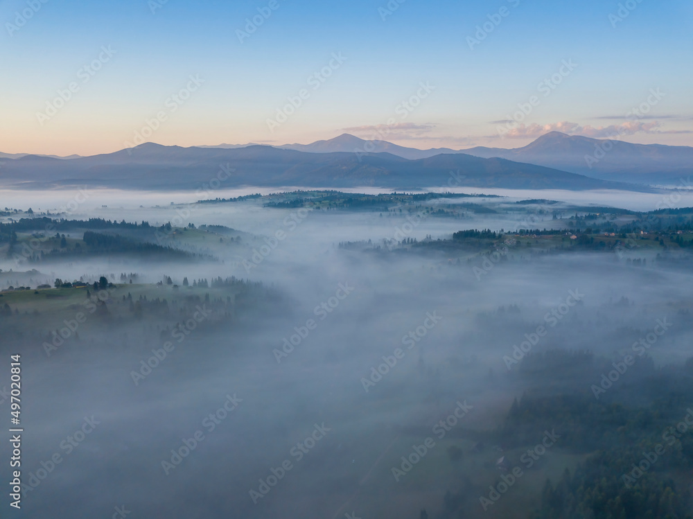 Flight over fog in Ukrainian Carpathians in summer. Mountains on the horizon. Aerial drone view. Flight over fog in Ukrainian Carpathians in summer. Mountains on the horizon. Aerial drone view.