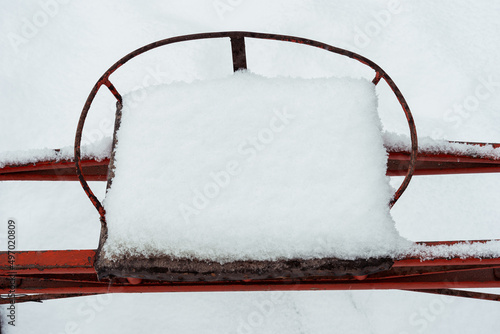 seat of an orange sulky in the snow photo