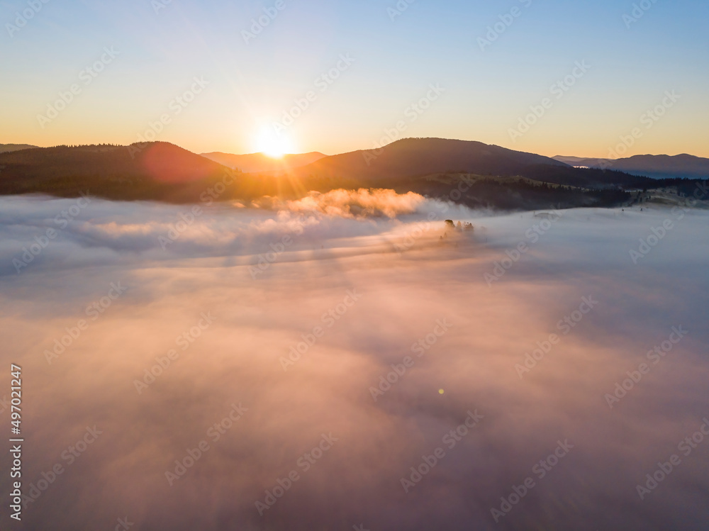 Sunrise over the fog in the Ukrainian Carpathians. Aerial drone view.