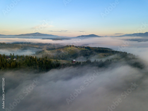 Fototapeta Naklejka Na Ścianę i Meble -  The rays of dawn over the fog in the Ukrainian Carpathians. Aerial drone view.