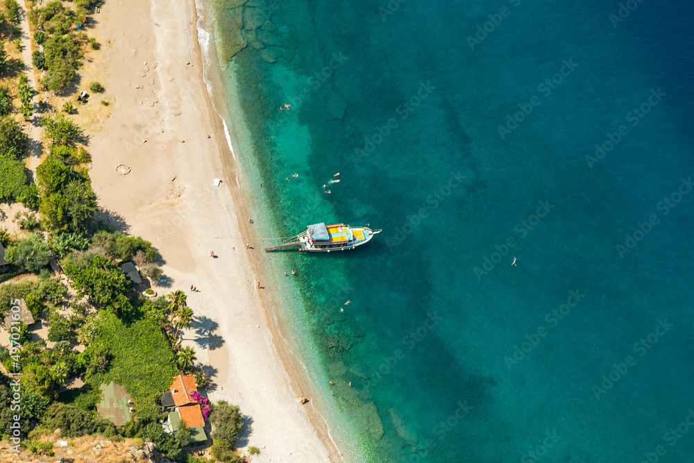 Amazing aerial view of Butterfly Valley in Fethiye Turkey. Summer landscape with mountains, green forest, azure water, sandy beach and blue sky in bright sunny day. Travel background. Top view. Nature