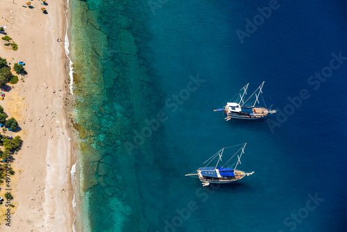 Amazing aerial view of Butterfly Valley in Fethiye Turkey. Summer landscape with mountains, green forest, azure water, sandy beach and blue sky in bright sunny day. Travel background. Top view. Nature