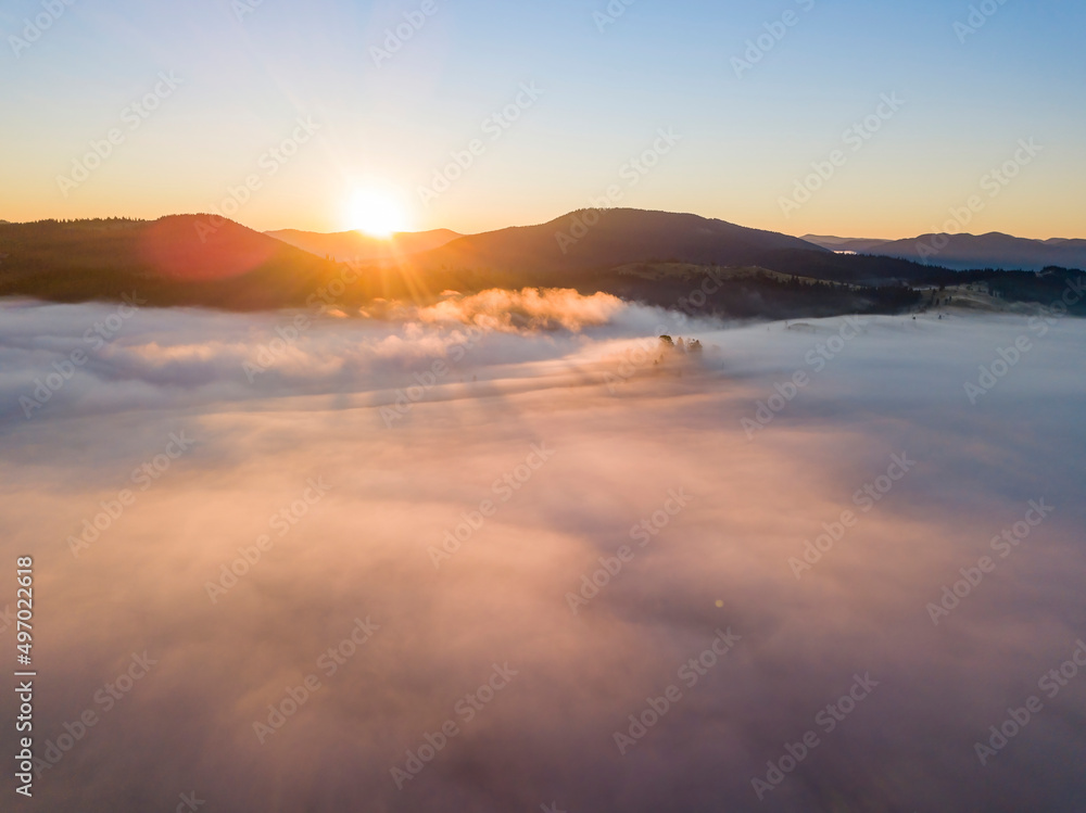 Sunrise over the fog in the Ukrainian Carpathians. Aerial drone view.