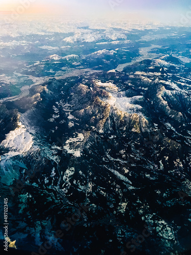 view from airplane of mountains with snow-capped peaks 