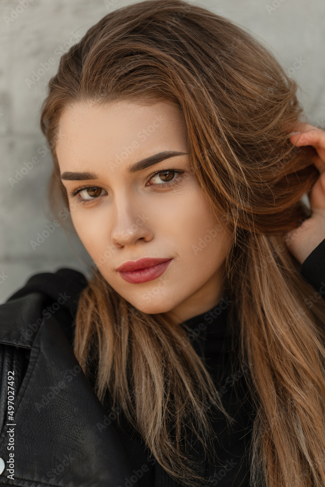 Naklejka premium Female young portrait of a beautiful stylish girl with a pretty face looking at the camera