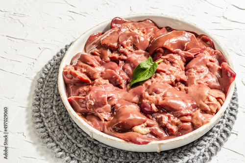 Raw chicken liver in a bowl. Fresh food ingredient and spices, trendy hard light, dark shadow