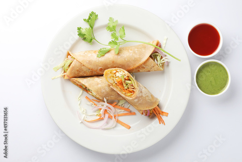 Indian Frankie Veg chapati Wrap / Kathi Roll, served in a plate with sauce & mint chutney. selective focus photo