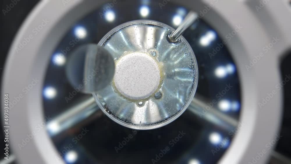 Effervescent tablet dissolves in liquid under a microscope. Effervescent tablet dissolves in liquid under a microscope.