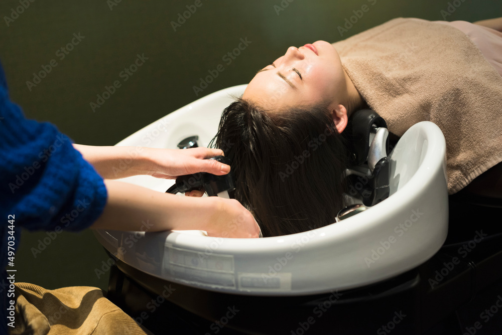 Obraz premium 美容室でシャンプーされる女性