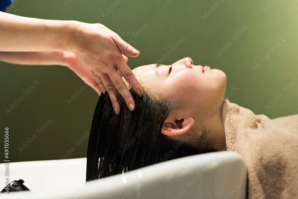 Fototapeta premium 美容室でシャンプーされる女性