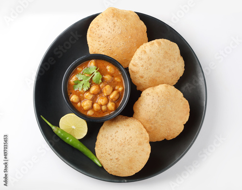 Puri and Chole traditional Indian food 
Indian dish spicy Chick Peas curry also known as Chola/Chana Masala or commonly Chole, served served with fried puri or poori   photo