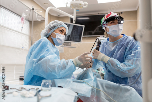 Surgeons operating on a man looking into a screen of health vital signs