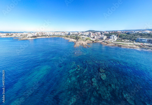 Aerial view of Alghero coastline under a blue sky