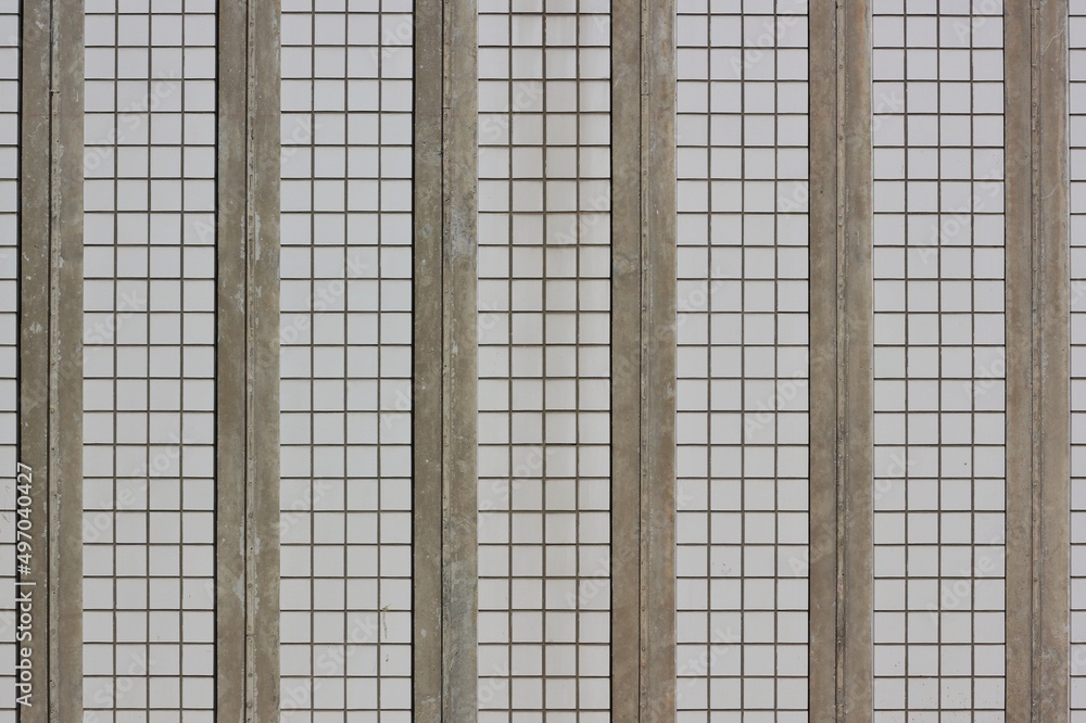 background of a wall covered with square ceramic tiles in beige and white