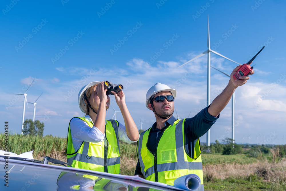 Φωτογραφία Engineer wearing uniform ,helmet inspection and survey work in wind turbine farms rotation to generate electricity energy