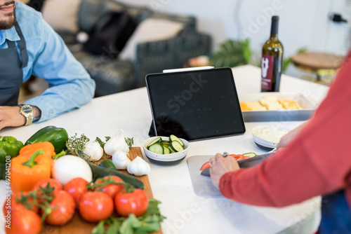 food in table front of couple  with tablet