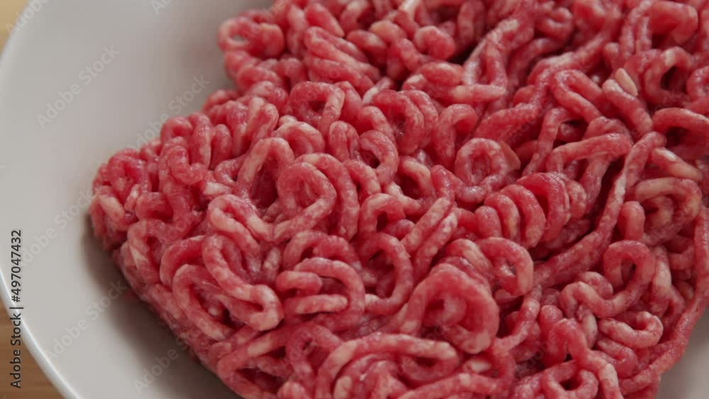 Macro tracking shot of raw ground beef meat in white ceramic bowl Macro tracking shot of raw ground beef meat in white ceramic bowl
