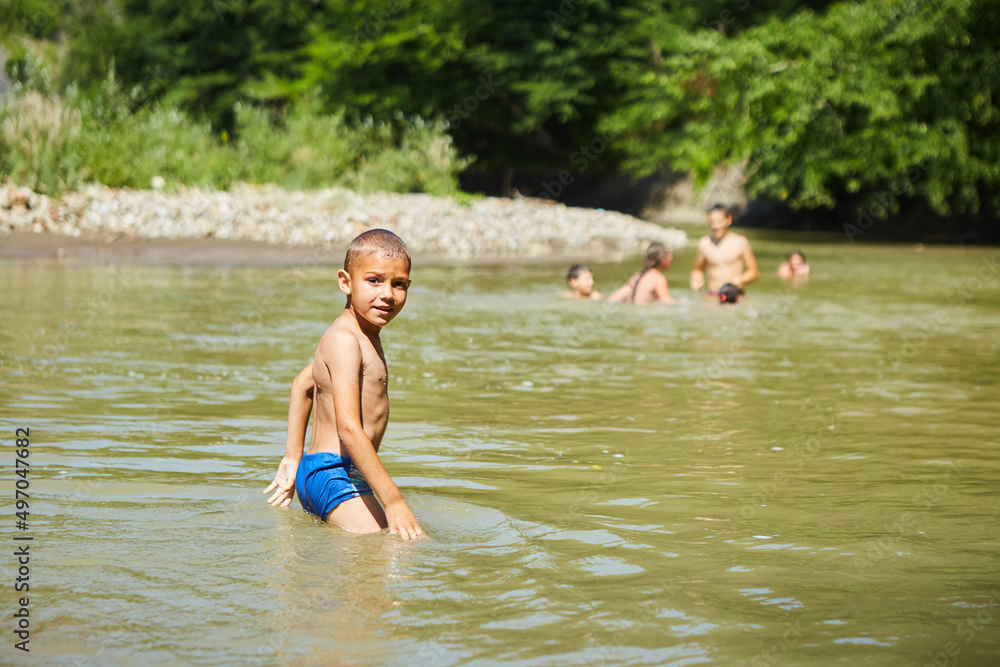 A boy is bathing in yellow river water. Rural recreation. A boy is bathing in yellow river water. Rural recreation.