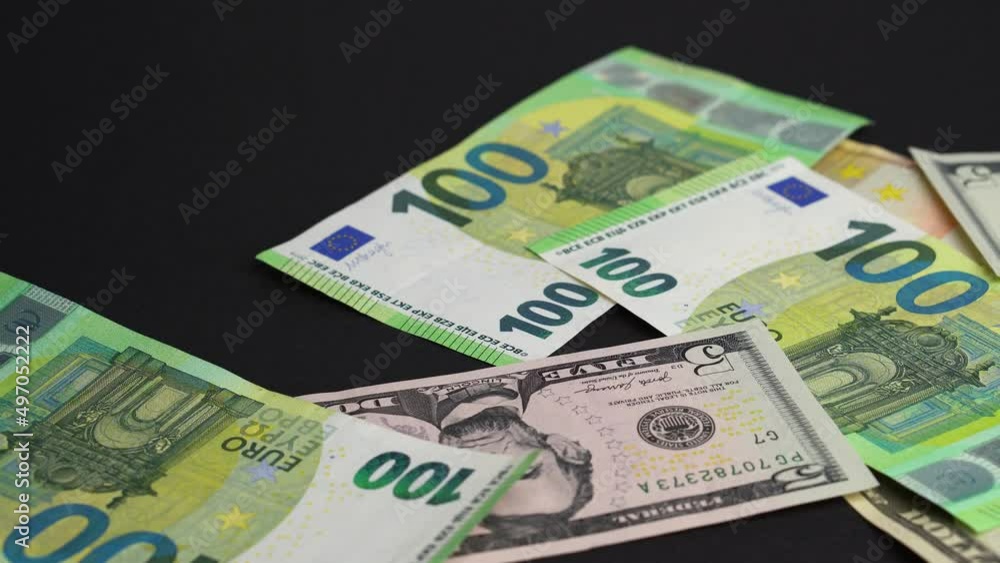 Money falling on table. Dropping lot of Euro and dollars paper banknotes on black background Money falling on table. Dropping lot of Euro and dollars paper banknotes on black background
