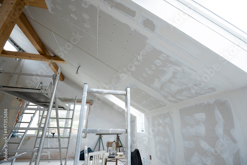 Attic finishing construction site in the phase drywall spackling and plastering before screeding