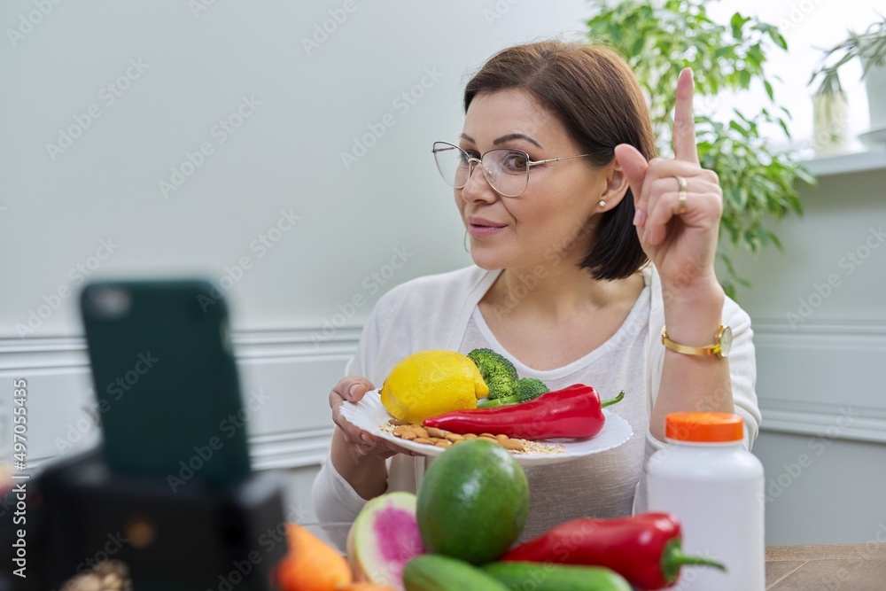 Woman recording video stream about healthy eating, vitamins, nutritional supplements Woman recording video stream about healthy eating, vitamins, nutritional supplements