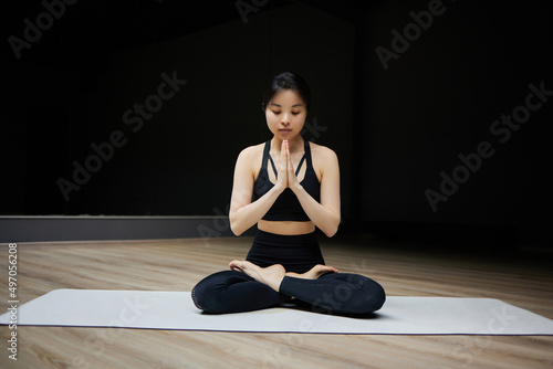 beautiful girl is doing yoga in the hall on a dark background