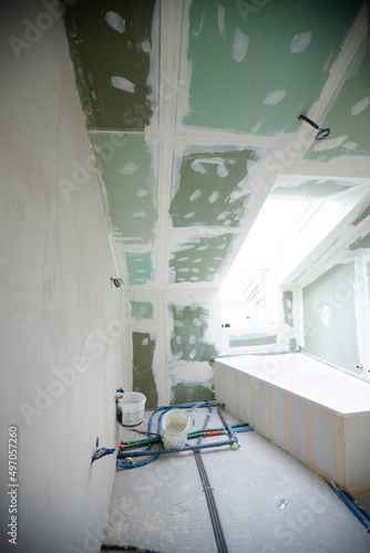 Attic finishing construction site in the phase drywall spackling and plastering before screeding