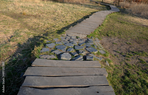 floating walkway made of wooden planks, pier, narrow curved paths on stilts driven to the bottom above the lake water. has no railings. more design sidewalk with low railings for wheelchairs photo