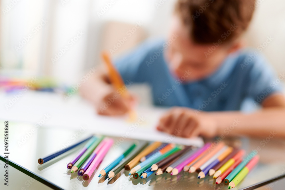 Selective focus. Little schoolboy drawing picture. Back to school. Home schooling and education at home Selective focus. Little schoolboy drawing picture. Back to school. Home schooling and education at home