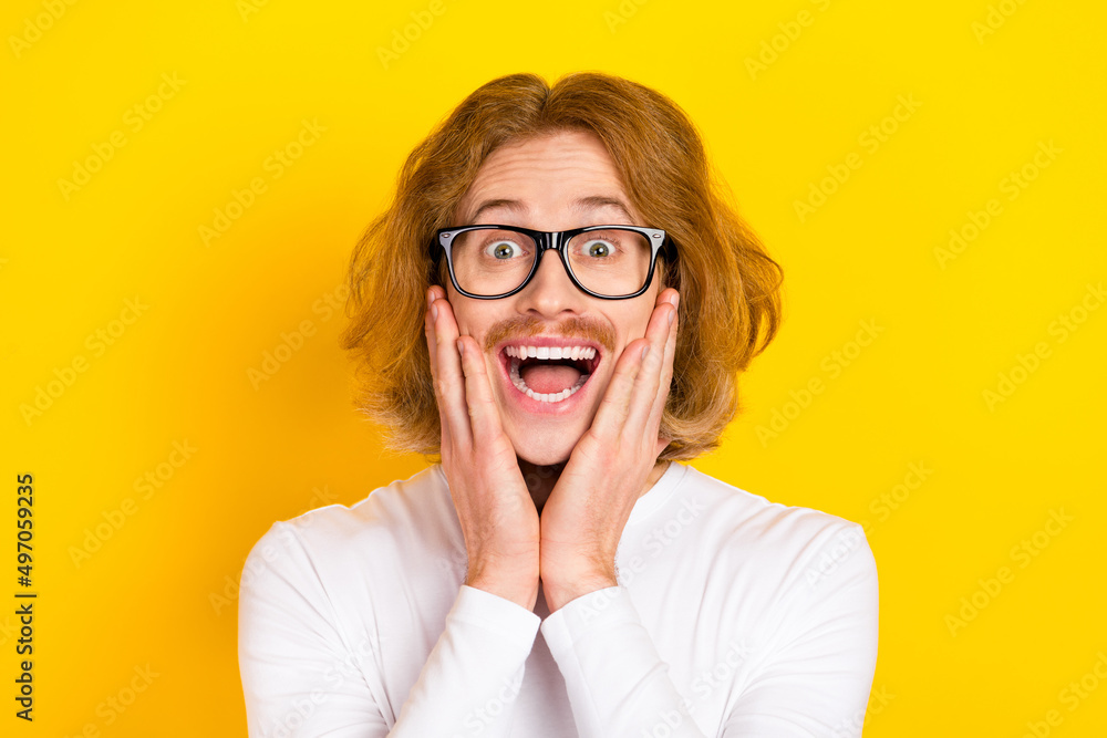 Photo of excited funky guy wear white shirt spectacles arms cheeks isolated yellow color background