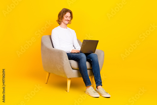 Full size photo of funny business male working in netbook make report read email document isolated on yellow color background