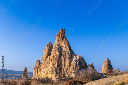 Fairy tale chimneys in Cappadocia with blue sky on background in Goreme,Nevsehir, Turkey. Volcanic rock landscape, Stone houses. 