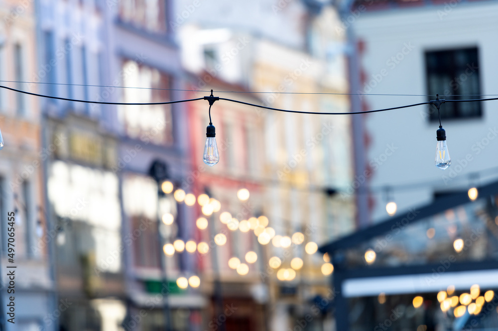 a row of electric light bulbs against a blurred old city background a row of electric light bulbs against a blurred old city background
