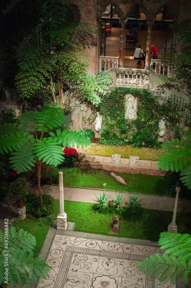 renaissance, byzantine and gothic style elements of arcade and a fountain decorating courtyard with tropical plants