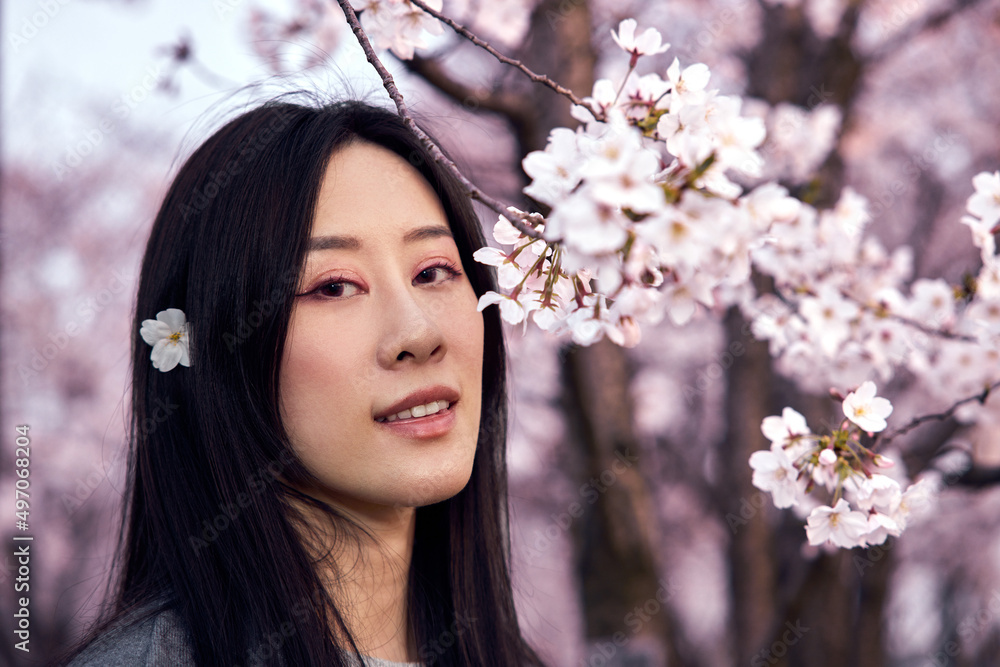 Beautiful Asian girl in cherry blossom garden on a spring day. Beautiful Asian girl in cherry blossom garden on a spring day.