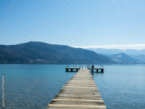 Panoramic view of Lake Attersee with wooden pier and mountain range in the background. Salzkammergut Upper Austria