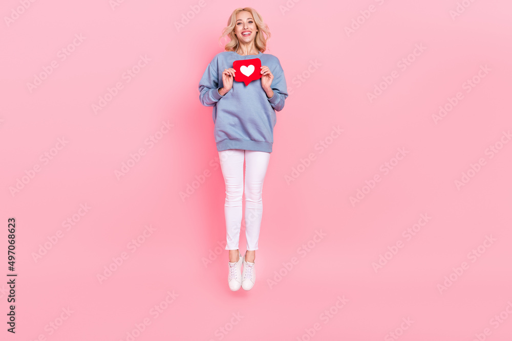 Full length photo of young lovely girl jump share repost button click user comment isolated over pink color background Full length photo of young lovely girl jump share repost button click user comment isolated over pink color background