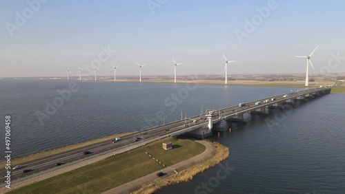 Drone flying towards highway on Bascule bridge, windmills in background. Ketelbrug