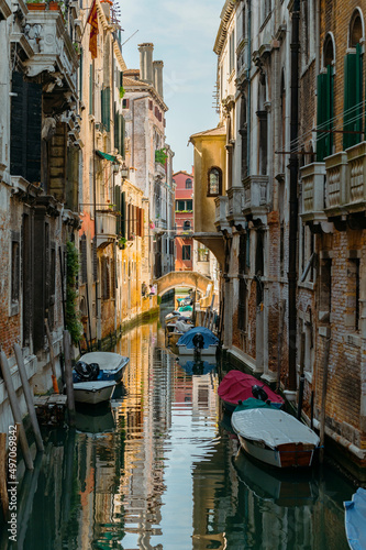 Venice, Italy - July 28 2021: Narrow canals with boats and gondolas in Venice, Italy