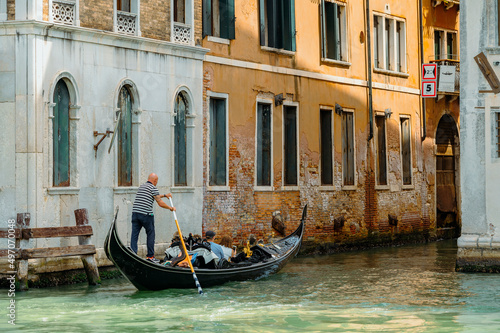 Venice, Italy - July 28 2021: Narrow canals with boats and gondolas in Venice, Italy