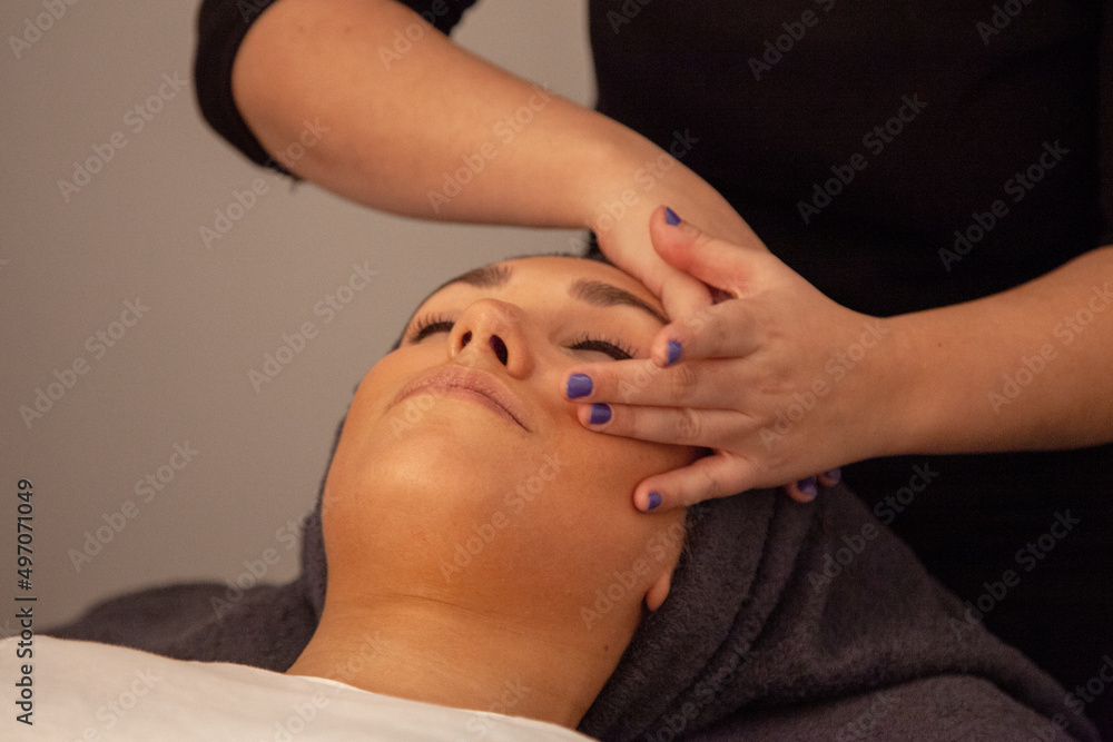 Masaje facial. Mujer recibiendo un masaje en la cara en una clínica de estética Masaje facial. Mujer recibiendo un masaje en la cara en una clínica de estética