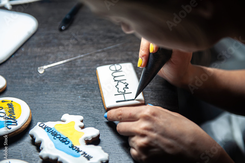 A woman makes patriotic gingerbread in support of Ukraine.