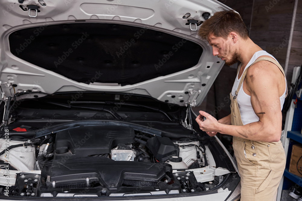 Close Up Shot of a Professional Mechanic Working on Vehicle in Car Service. Close Up Shot of a Professional Mechanic Working on Vehicle in Car Service.
