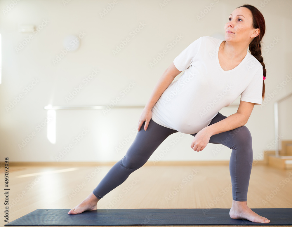 Pregnant woman is engaged in yoga. Extended Side Angle or Utthita Parsvakonasana Pregnant woman is engaged in yoga. Extended Side Angle or Utthita Parsvakonasana