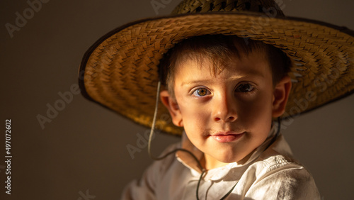 Niño juguetón feliz sonriente expresivo posando con sombrero campesino vaquero disfrutando photo