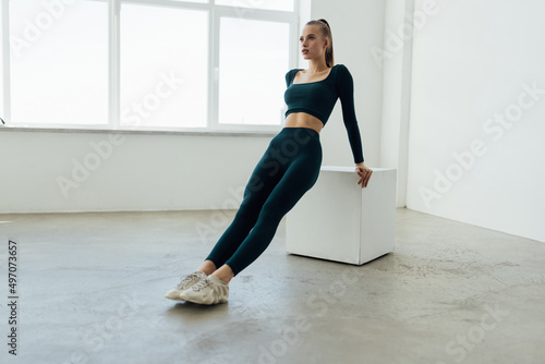 Photo of a young woman doing exercises a box at the gym.