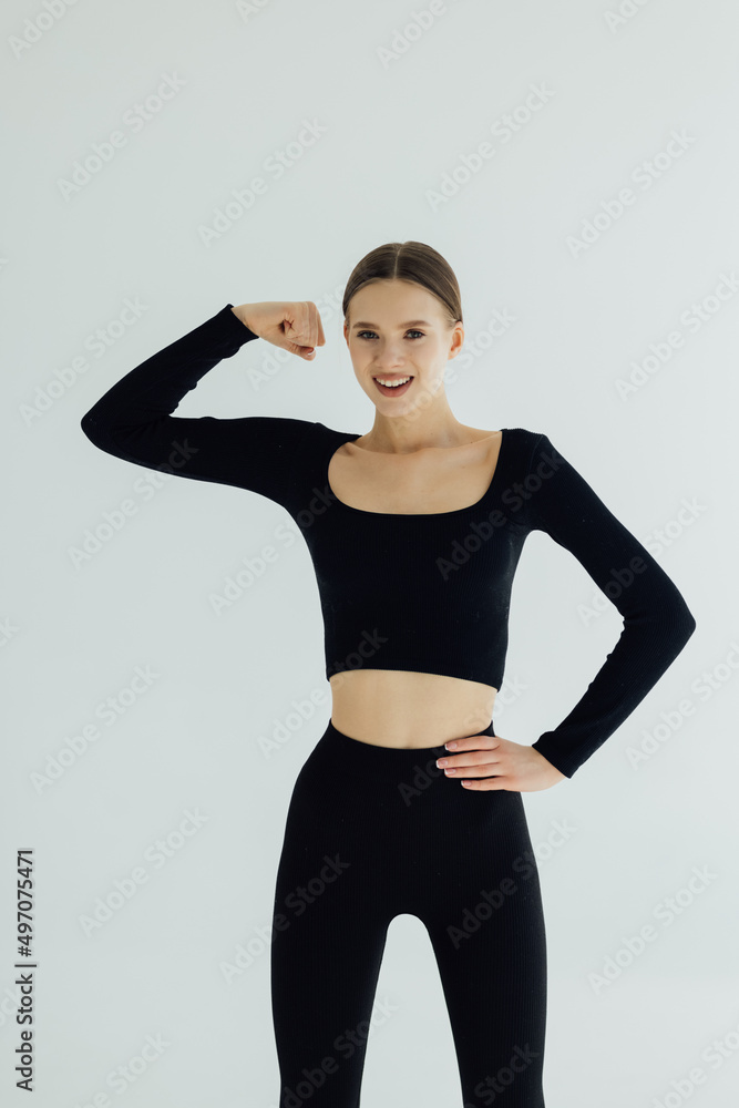 Cheerfully smiling sporty woman demonstrating biceps, isolated on white background Cheerfully smiling sporty woman demonstrating biceps, isolated on white background
