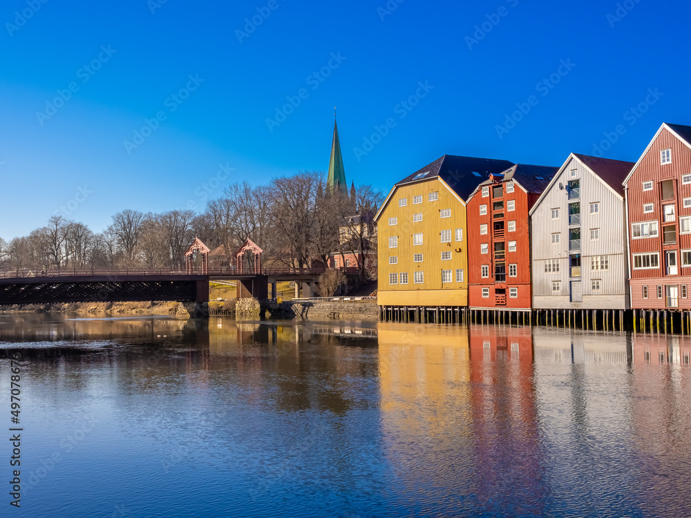 Obraz premium Scenes on the shores of the Nidelva river, with the old town bridge and the spire of the Nidaros Cathedral, Old town of Trondheim, Trøndelag, Norway