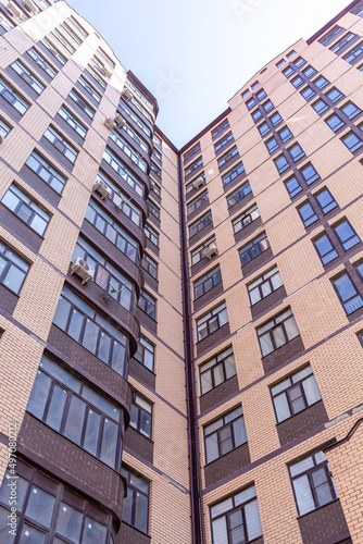 New multi-apartment high-rise buildings made of brick. Apartments with repairs, windows and air conditioning. The neighborhood of new houses.